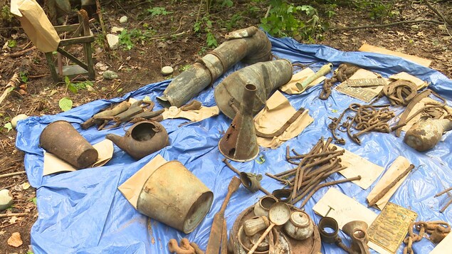 Des artefacts retrouvés lors de fouilles archéologiques sont posés sur une bâche de plastique. Des artefacts retrouvés lors de fouilles archéologiques sont posés sur une bâche de plastique.