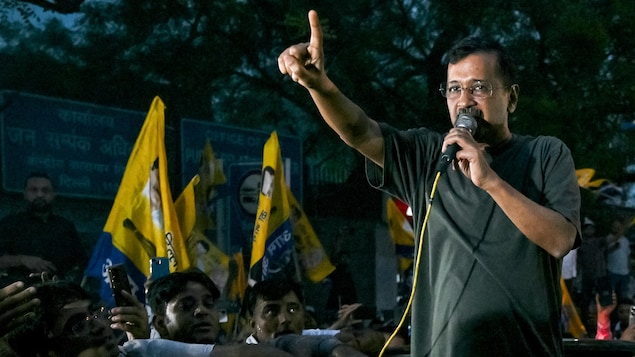 Arvind Kejriwal se tient debout entouré par une foule. Il parle dans le micro, le 10 mai 2024 à New Dehli.
