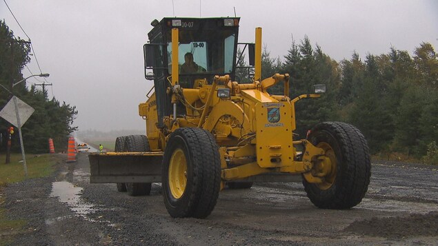 Un employé de la municipalité est dans une machinerie pour réparer la route. Un employé de la municipalité est dans une machinerie pour réparer la route.