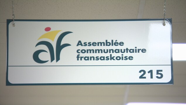 Une affiche dans un corridor sur laquelle on peut voir le logo de l'Assemblée communautaire fransaskoise.