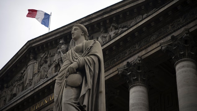 Plan en contre-plongée d'une statue devant l'Assemblée nationale française.