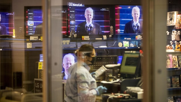 Joe Biden apparaît sur des téléviseurs dans une boutique d'équipement électronique à Vancouver.