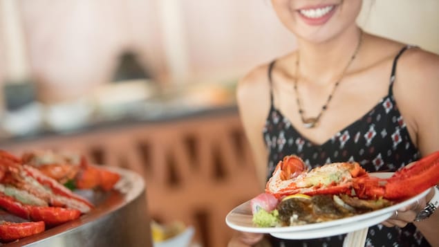 Une femme avec une assiette de homard.