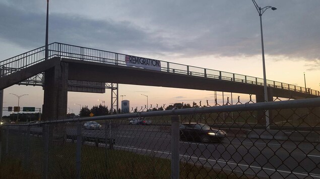 Une banderole « #remigration » suspendue au-dessus de l'autoroute Henry IV. Une banderole « #remigration » suspendue au-dessus de l'autoroute Henry IV.