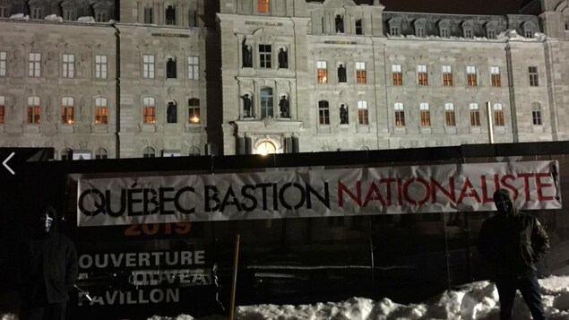 Des membres masqués d'Atalante devant l'Assemblée nationale. Des membres masqués d'Atalante devant l'Assemblée nationale.