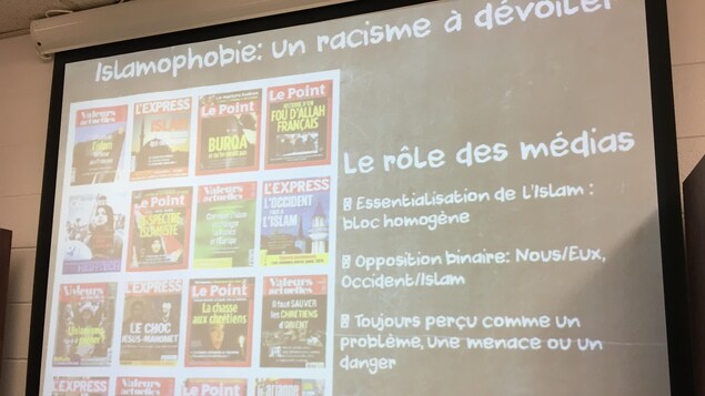 Une projection où on peut lire les mots suivants : Islamophobie, un racisme à dévoiler. Le rôle des médias. Une projection où on peut lire les mots suivants : Islamophobie, un racisme à dévoiler. Le rôle des médias.