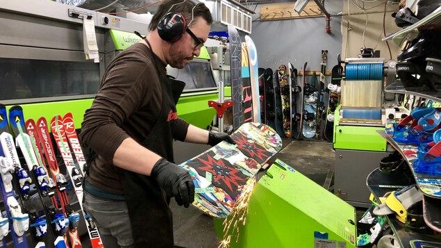 Un employé ajuste une planche à neige dans l'atelier du magasin La Vie Sportive, La Cordée. Un employé ajuste une planche à neige dans l'atelier du magasin La Vie Sportive, La Cordée.