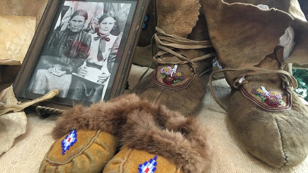 Deux paires de mocassins et un cadre sont disposés sur une table.