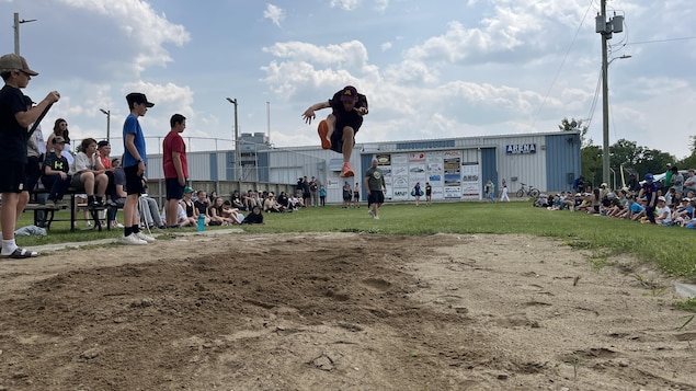 Un athlète fait un saut en longueur.
