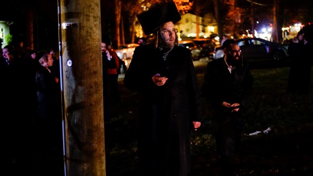 Des juifs regardent les policiers intervenir de l'extérieur.