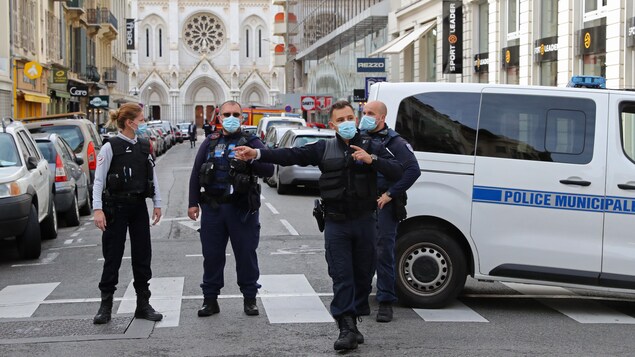 Quatre policiers se tiennent dans la rue.