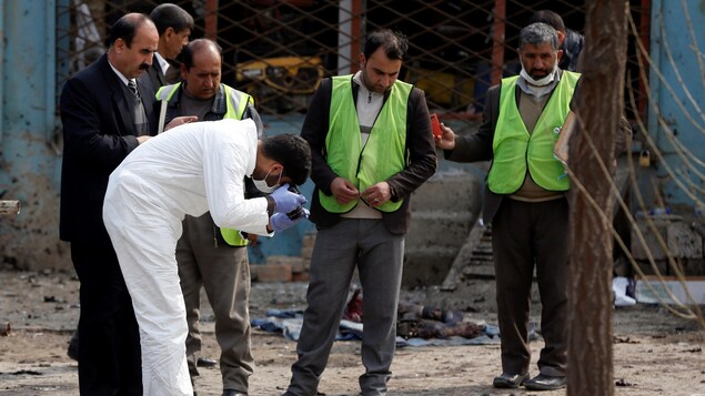 Un expert judiciaire photographie des débris au sol. Un expert judiciaire photographie des débris au sol.