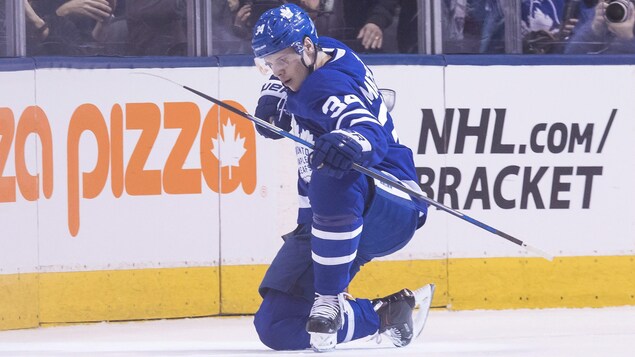 Auston Matthews met un genou sur la glace et fait un mouvement du bras pour fêter un but. Auston Matthews met un genou sur la glace et fait un mouvement du bras pour fêter un but.