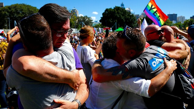Des couples s'étreignent à Sydney à la suite d'un vote national qui démontre qu'une majorité d'Australiens est en faveur du mariage entre personnes de même sexe. Des couples s'étreignent à Sydney à la suite d'un vote national qui démontre qu'une majorité d'Australiens est en faveur du mariage entre personnes de même sexe.