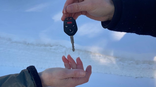 Un homme donne sa clé de voiture à une femme.