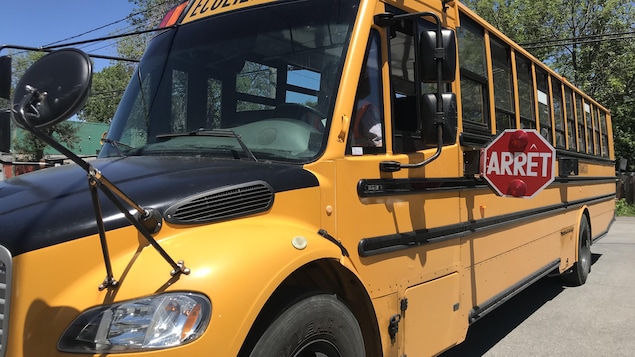 Un autobus scolaire avec son panneau arrêt déployé Un autobus scolaire avec son panneau arrêt déployé