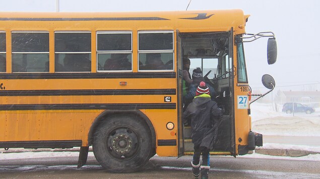 Des élèves montent dans un autobus scolaire. Des élèves montent dans un autobus scolaire.