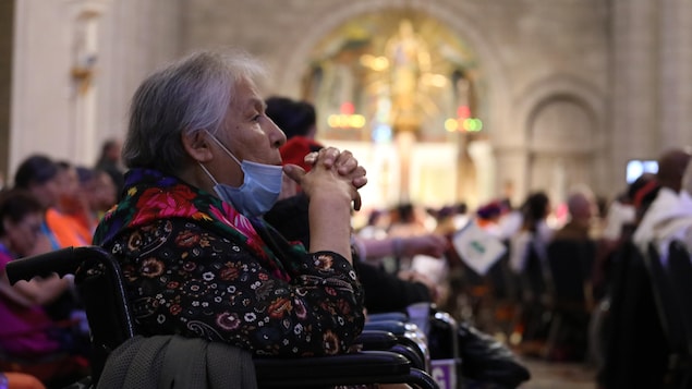 Une femme autochtone dans un fauteuil roulant qui assiste à la messe du pape.