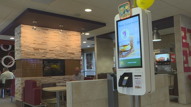 Vue intérieur d'un restaurant. Une machine libre-service à l'avant-plan Vue intérieur d'un restaurant. Une machine libre-service à l'avant-plan