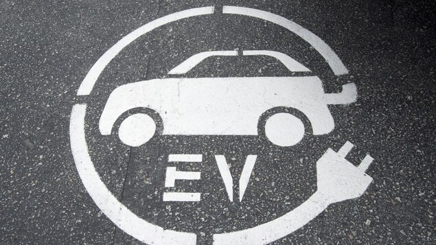 Symbole de borne de recharge pour voiture électrique peint sur la chaussée. Symbole de borne de recharge pour voiture électrique peint sur la chaussée.