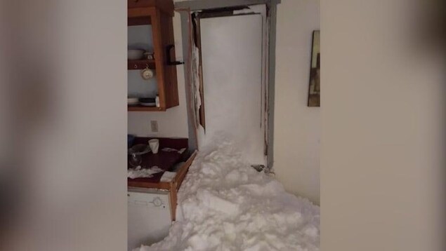 Une maison envahie de neige.