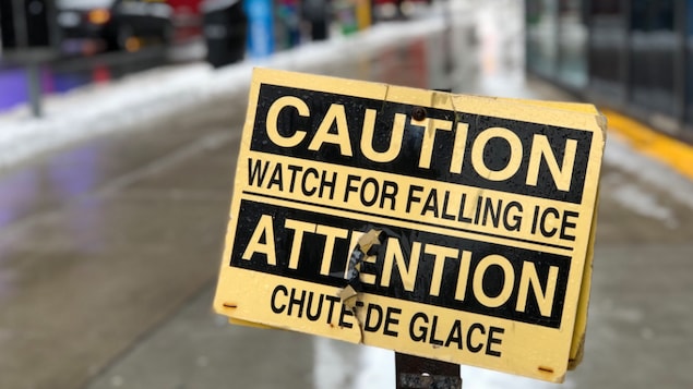 Photo d'une affiche d'avertissement jaune et noire qui dit « Attention, chute de glace » Photo d'une affiche d'avertissement jaune et noire qui dit « Attention, chute de glace »