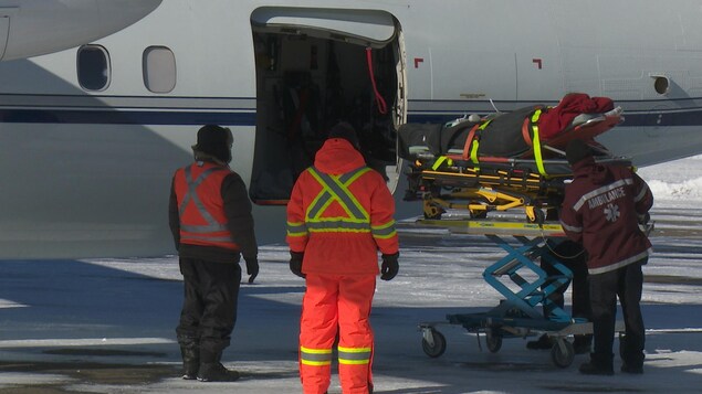 Patient sur une civière qui entre dans l'avion Patient sur une civière qui entre dans l'avion
