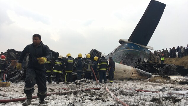 Des secouristes près de l'épave d'un avion. Des secouristes près de l'épave d'un avion.