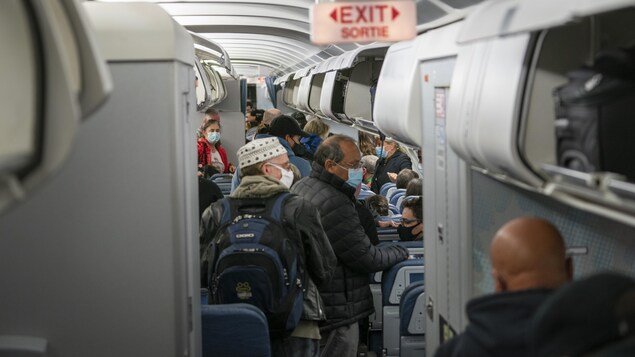 Pasajeros en un vuelo aéreo se preparan a desembarcar.