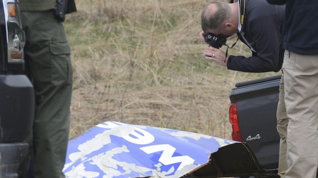 Un enquêteur du Bureau américain de la sécurité des transports photographie un morceau de revêtement de moteur qui a été retrouvé après l'accident d'un avion de Southwest Airlines. Un enquêteur du Bureau américain de la sécurité des transports photographie un morceau de revêtement de moteur qui a été retrouvé après l'accident d'un avion de Southwest Airlines.