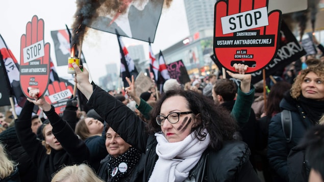 Des femmes tiennent des pancartes sur lesquelles est écrit « Stop la loi antiavortement ».
