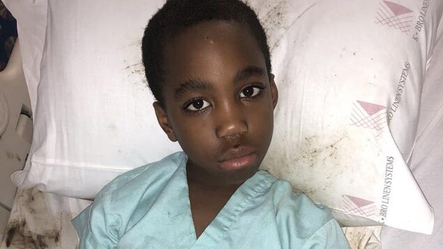 Photo d'un jeune garçon noir, la tête sur un oreiller. Photo d'un jeune garçon noir, la tête sur un oreiller.