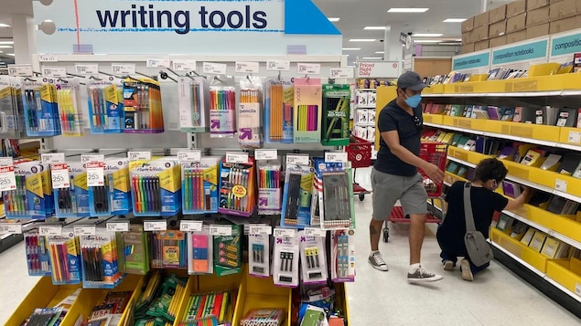 Two people in a school staples store looking at notebooks.