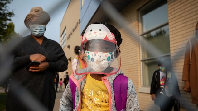 A Toronto elementary school student wears full PPE before heading into class last September. Students will continue to wear masks inside classrooms as part of Ontario's new plan.