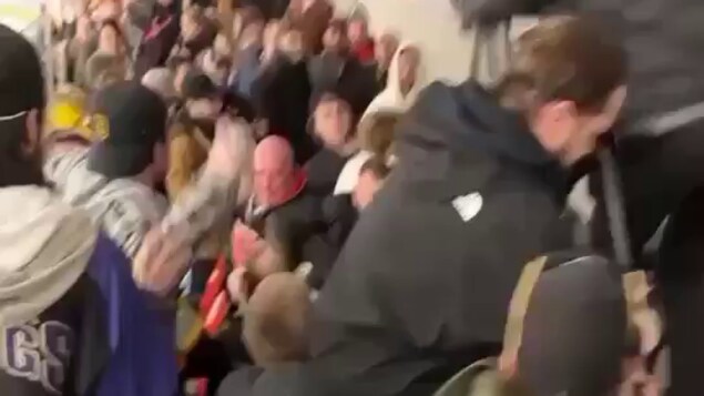Une foule avec des gens s'échangeant des coups.