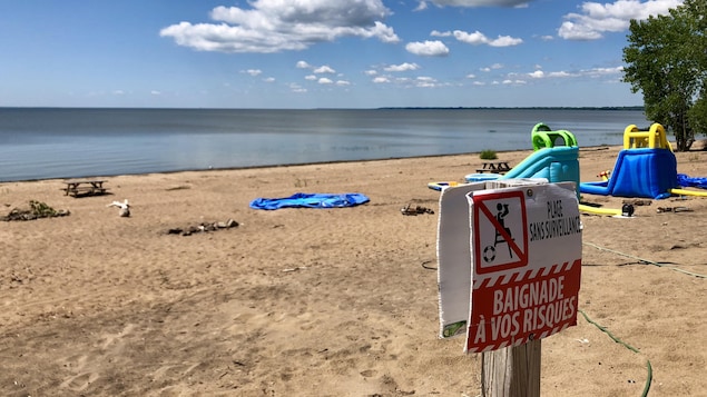 Sur une plage, une pancarte sur laquelle on peut lire « Plage sans surveillance, baignade à vos risques » Sur une plage, une pancarte sur laquelle on peut lire « Plage sans surveillance, baignade à vos risques »
