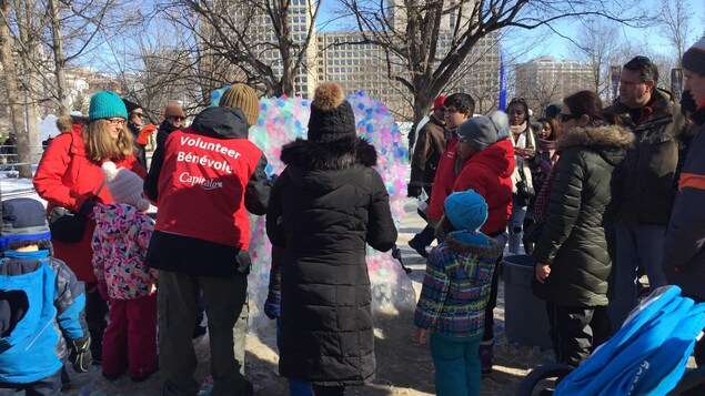 Des participants au Bal de Neige devant une oeuvre de glace collective au parc de la Confédération. Des participants au Bal de Neige devant une oeuvre de glace collective au parc de la Confédération.