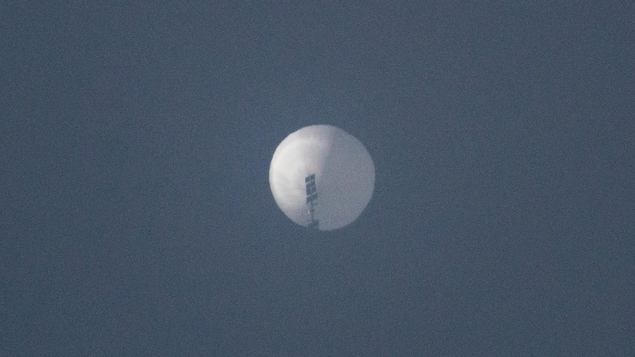 Une tache blanche dans le ciel sur laquelle on distingue la silhouette d'antennes et d'appareils de télécommunications.
