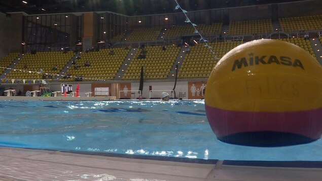 Un ballon de water-polo en gros plan, sur le bord de la piscine