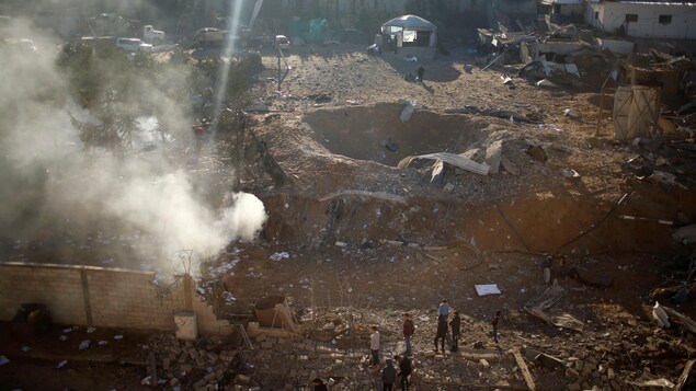 Des Palestiniens observent les résultats d'un bombardement aérien effectué par Israël contre des positions du groupe militant Hamas dans la bande de Gaza. Des Palestiniens observent les résultats d'un bombardement aérien effectué par Israël contre des positions du groupe militant Hamas dans la bande de Gaza.