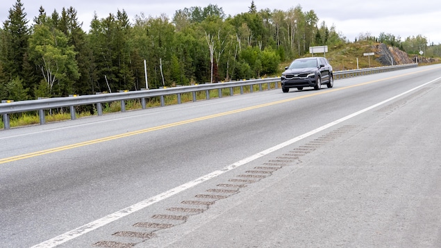 Un véhicule roule sur une route dotée de bandes rugueuses.