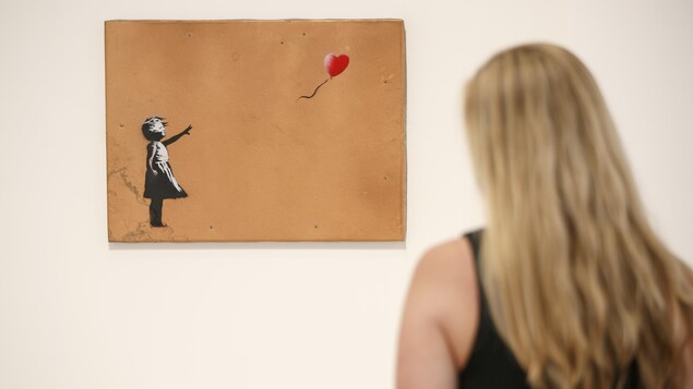 Une femme regarde le tableau, une petite fille qui lache un ballon rouge. Une femme regarde le tableau, une petite fille qui lache un ballon rouge.