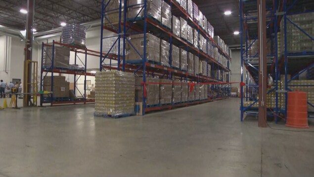 De grandes tablettes qui regorgent de denrées, placées dans des boîtes, dans le grand entrepôt de la Banque d'alimentation d'Ottawa.