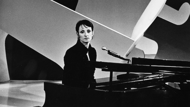 Dans un studio de télévision, la chanteuse française Barbara interprète une chanson, assise derrière un piano.