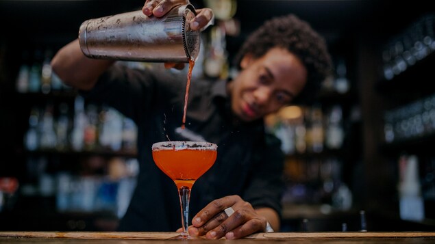 Un barman verse un cocktail dans un verre. Un barman verse un cocktail dans un verre.