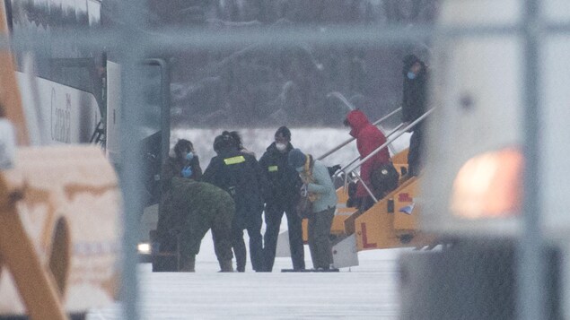 Les Canadiens évacués de Wuhan, en Chine, descendent de l'avion qui les a conduits à Trenton, en Ontario.