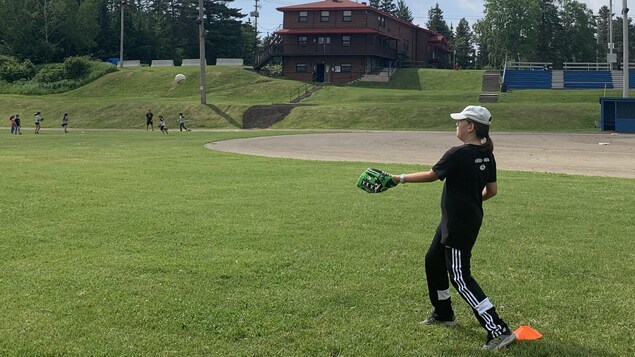 Une jeune fille sur le terrain de baseball.