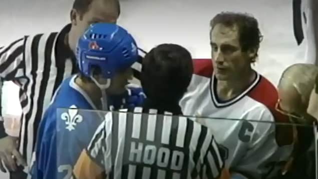Les capitaines Bob Gainey, des Canadiens de Montréal et Mario Marois, des Nordiques de Québec, discutent avec les arbitres près de la bande. 