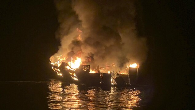 Le bateau en flammes pendant la nuit.