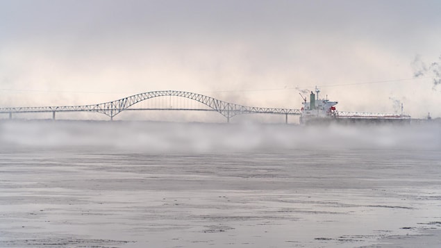 Le pont Laviolette et un bateau avec de la brume qui sort de l'eau tellement il fait froid.